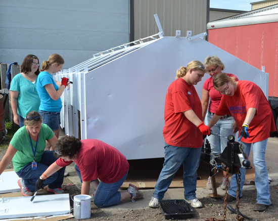 Bridges to Transition participants and their job coaches work on painting a trailer at the Van Wert Solid Waste Management District's recycling center on North Washington Street. (Dave Mosier/Van Wert independent)