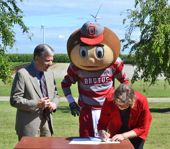 Kevin Lynch (left) of Iberdrola Renewables and Brutus Buckeye watch as OSU Vice President for Research Caroline Whitacre signs a research agreement between the two entities. (photos by Dave Mosier/Van Wert independent)