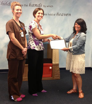 Kim Haas (left) of the Van Wert County Health Department, presents an award to Dr. Jennifer Hohman, while Dr. Hohman's nurse, Morgan Owens, looks on. (photo submitted)