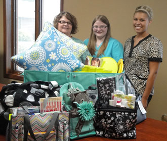Shown with some of the prizes for the “31” Bag Bingo fundraiser are (from the left) Lisa Agler, Malorie Brown, and Kristy Scherman. (Family Health Care photo)