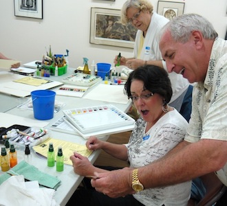 World-renowned watercolorist Tom Lynch demonstrates some of the amazing properties of a paintbrush to students. (Photo submitted.)