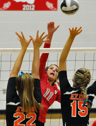 Van Wert volleyball player Taylor Doidge hits one over the heads of a pair of Elida defenders during Thursday's Western Buckeye League contest. (Jan Dunlap/Van Wert independent)
