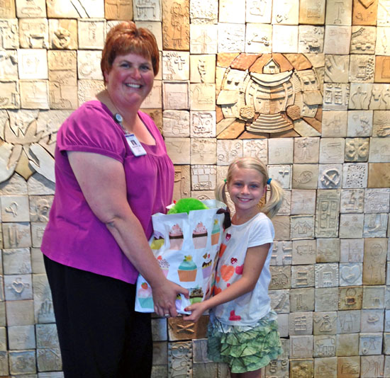 Whitley Fast, a 9-year-old Van Wert Elementary School student, presents a bagful of gifts to Sammi Joseph, director of inpatient services at Van Wert County Hopsital. (VWCH photo)