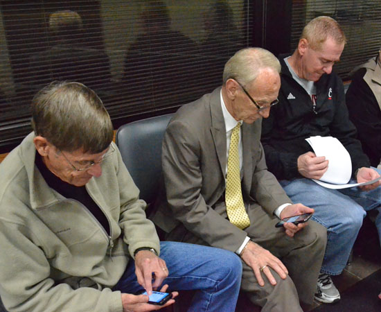 Van Wert Safety-Service Director Jay Fleming (right) checks election returns while Mayor Don Farmer (center) and aquatic center support Dave Mathew text messages on their cell phones following Tuesday's general election. (Dave Mosier/Van Wert independent)