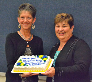 Outgoing Lincolnview board members Cindy Miller (left) and Sally Snyder hold a cake honoring them for their combined 40 years of service to the board. (Dave Mosier/Van Wert independent)