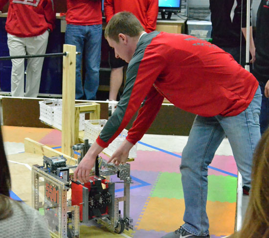 Junior Ryan Rice makes an adjustment to the VWHS Robotics Club robot, USS Enterprise, prior to a demonstration run at the high school on Wednesday. (Dave Mosier/Van Wert independent)