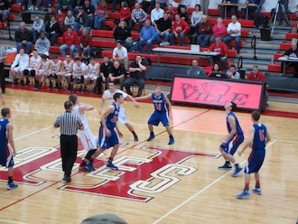 Tyson Bolenbaugh tips the ball back to Cameron Etzler and Damian Helm during their game on Feb. 1 against Hicksville. (Photo submitted.)