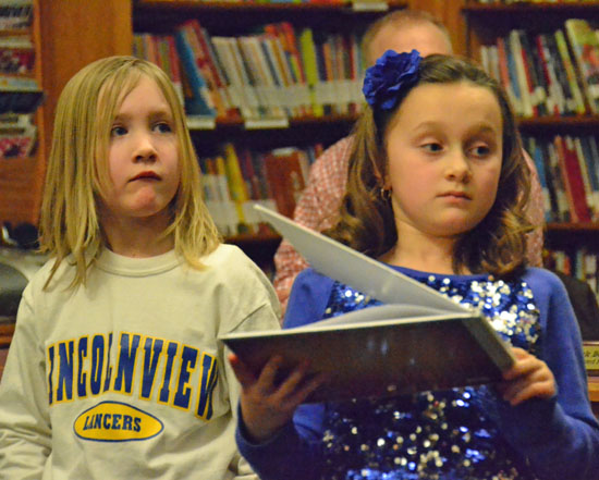 Lily Wyatt and Allie Miller, both first-graders in Patti Cox's class, read from books they created during Wednesday's Lincolnview Local Board of Education meeting. (Dave Mosier/Van Wert independent)