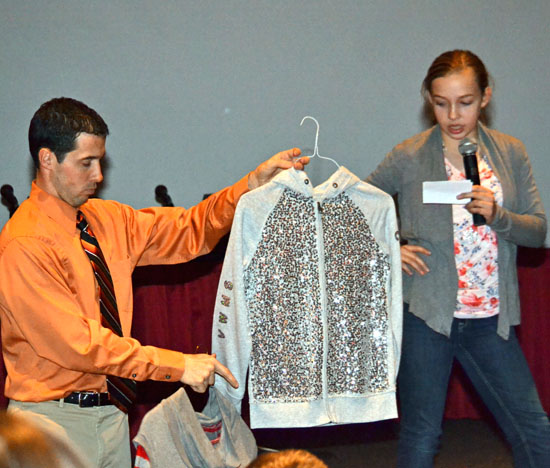 Van Wert Middle School student Savannah Nygren talks about Cougar-themed clothes items she designed while teacher Brendon Moody holds up a sample during a prevention to the Van Wert City Board of Education on the Genius Hour project-based program. (Dave Mosier/Van Wert independent