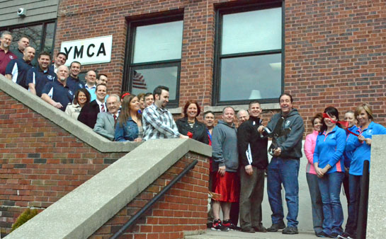 YMCA Executive Director Hugh Kocab cuts the ribbon celebrating the YM's 100-year anniversary as Van Wert Area Chamber of Commerce board members, YMCA board members and staff look on. (Dave Mosier/Van Wert independent)