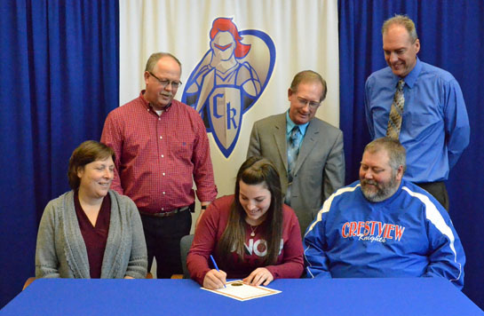 Kirstin Hicks signs her letter of intent, as parents Glenn and Diana Hicks (seated) coaches Owen Pugh and Carl Etzler and Crestview Athletic Administrator Dave Bowen look on. (Dave Mosier/Van Wert independent)