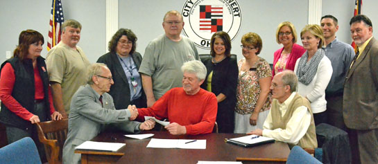 Members of the Van Wert Community Development Revolving Loan Fund look on as Mayor Don Farmer congratulates Rick Racster on his receiving a city loan for a new business, Van Wert Lumber. (Dave Mosier/Van Wert independent)