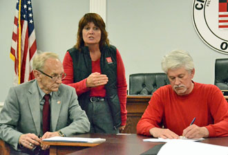 Rick Racster (right) signs loan papers while Economic Development Specialist Darlene Myers explains the loan requirements and Van Wert Mayor Don Farmer looks on. (Dave Mosier/Van Wert independent)