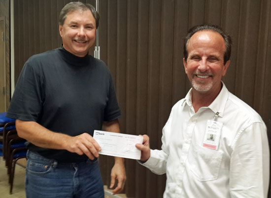 Pat Tracy (right), administrator at Ridgeview, presents Fair Board President Brian Etzler with a sponsorship check for the “Build a New Band Show 2014” event. (photo submitted)
