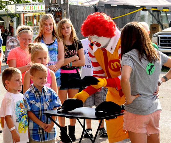Ronald McDonald shows off a trick to some fascinated youngsters on Wednesday at the Van Wert County Fair. (Jan Dunlap/Van Wert independent)