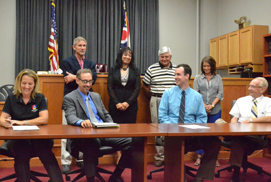 There were smiling faces all around with the announcement that Van Wert County was awarded a $300,000 downtown revitalization grant. Shown are (seated) Van Wert County Economic Development Director Sarah Smith, Commissioner Todd Wolfrum, Main Street Van Wert Program Manager Adam Ries and Van Wert Mayor Don Farmer; (standing) Commissioner Thad Lichtensteiger, Van Wert Municipal Court Judge Jill Leatherman, Van Wert City Councilman Jerry Mazur and OSU Extension Community Development Manager Cindy Leis. (Dave Mosier/Van Wert independent)