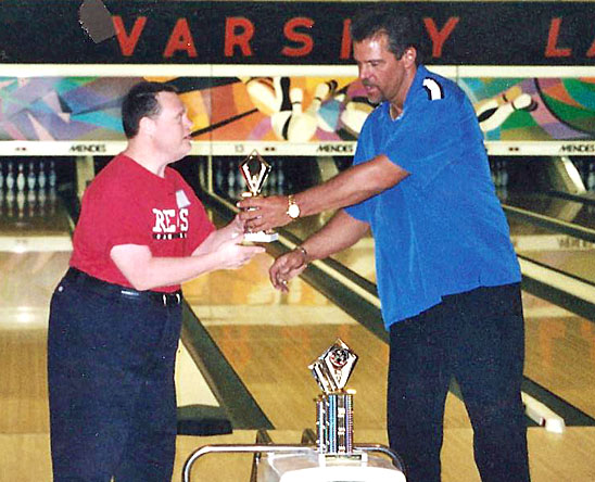 Kenny Bockey (left) receives a bowling trophy through a local Special Olympics program. (photo submitted)