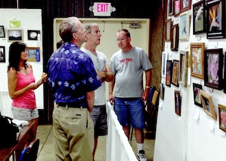 Judge Elmer Denman (foreground), selects the winning photographs as (left to right) Barb Jewett, Stuart Jewett, and Karl Gribler, place ribbons. (Photo submitted.)