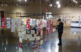 Artist Saffron Goetschius inspects some of the postcards in her solo exhibit, The Symphony of My Heart, now on display at the Wassenberg Art Center. (Photo submitted.)