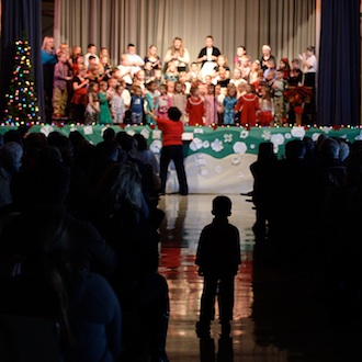 A young audience member at the St. Mary of the Assumption School performance of “An Old Fashioned Christmas” moves himself to the center aisle for better view of the production. (Photo submitted.)