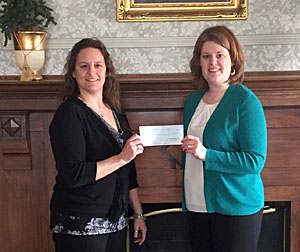 Danni Chiles (left), YWCA finance manager, receives a donation from Rachel Schepman, community relations manager for Ruler Foods. (YWCA photo)