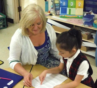 Mary Yackey working with one of her students on reading assignment. (Photo submitted.)