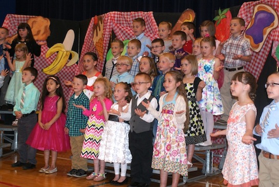Crestview Elementary hosted the annual Kindergarten Recognition Program, entitled “Yummy, Yummy in My Tummy” on Tuesday, May 12.  Kindergarteners sang a number of musical selections and were presented with certificates signifying the completion of their kindergarten year.  Art projects were also on display for parents and guests to view.  Anyone who wishes to purchase a DVD of the program ($5 each) can do so by contacting the Crestview Elementary office at 419.749.9100, ext 1. Pictured are Crestview kindergarteners singing “C  is for Cookie” during the Kindergarten Recognition Program.   (Photo submitted.)