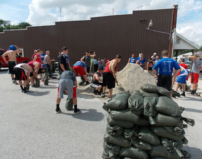 Members of the Crestview football team help place sandbags at a Willshire business. (photo by Rick McCoy for the VW independent)