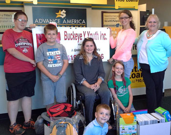 Shown are (front row) Connor Partin, with some of the donated school supplies; (back row, from the left) Skyler Lewis, Ashton Lewis, Buckeye Y Youth Board Member/Safe & Secure Instructor Carey Partin, Anna Partin, Emma Partin and Advance America Manager Tammy Methot. (Buckeye Y Youth photo)
