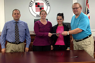 Gen-X Training owners Kelly Stevenson and Trisha Breese receive a check from Van Wert City Council President Ken Mengerink (right), a member of the city Revolving Loan Committee, while RLF Committee member Mark Verville looks on. (photo submitted)