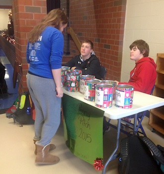 Student Council members Dylan Hicks and Ford Tatum work the Penny Pitch table at lunch time. Classes compete against one another with positive and negative points from their donated change.  (Photo submitted.)