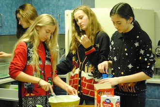 Olivia Skelton, Lizzie Bowen, and Haley Speith stir up a recipe for pancakes on Friday morning to cook for FCCLA to eat with the special needs students. (Photo submitted.)