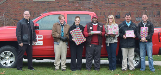 Employees of Lee Kinstle GM Sales & Service and the Van Wert County Family YMCA holds presents collected through the Toss A Toy Program. (photo submitted)