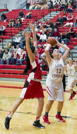Van Wert's Abby Jackson (12) attempts to make a basket under pressure during Thursday's Western Buckeye League contest against Wapakoneta. The Cougar lost the game, 83-28. (Bob Barnes/Van Wert independent)