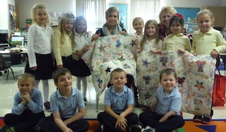 The Kindergarten class presents the quilts that they made to be given to expectant mothers to Mrs. Langdon of the Pregnancy Life Center  (Photo submitted.)