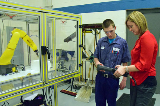 Vantage Board of Education member Kim Wannemacher (right) operates a robotics machine under the tutelage of student Josiah Dealey. (Dave Mosier/Van Wert independent)