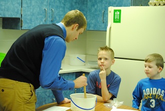 Foods student Connor Lautzenheiser teaches first grade students how to made bread for a class project. (Photo by A. Boroff.)