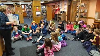 On Feb. 22 the Lancer Learning Academy took a field trip to the Brumback Library. At the library, students were given a tour of the different areas and told about its history. Students are shown listening to Marsha Weldy read a story about George Washington’s teeth. (Photo submitted.)