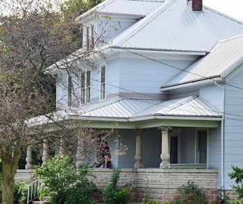 A Van Wert County sheriff's deputy walks along the porch of 304 S. Adams St. in Middle Point. Deputies served a search warrant at the house and other sites on Wednesday in support of a Van Wert Police Department investigation. photos by Dave Mosier/Van Wert independent