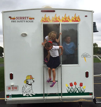 Local students exit the smoke-filled Fire Safety House this week. (photo submitted)