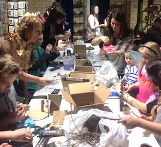 Participants of all ages who attended the Enchanted! Opening party at the Wassenberg Art Center gathered around the makers table to create fairy doors. Diane Bendele, ArtReach afterschool art program instructor assists. (Photo submitted.)