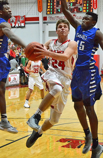 Van Wert's Dylan Lautzenheiser (24) drives the lane against two Carroll defenders in Saturday's non-conference game in The Den. Jan Dunlap/Van Wert independent