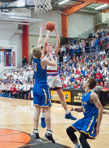Crestview's Javin Etzler (15) shoots from the top of the key over a Delphos St. John's defender during Friday's Division IV district tourney finals at the Elida Fieldhouse. Bob Barnes/Van Wert independent