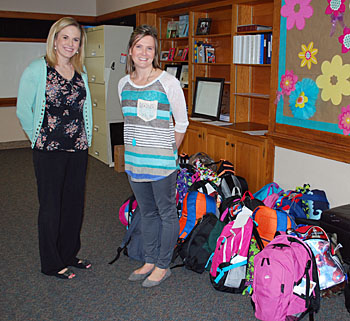 Shown is Melissa Gearhart (left), Marsh Foundation foster care supervisor, with Kayla Bagley from Closet 1:27 and that organization’s donation of foster journey bags. (photo submitted)