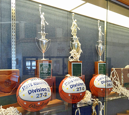 The 196-97 Lancer boys' basketball team's state championship trophy is flanked by state runner-up trophies earned in 1996 and 2016 in the Lincolnview High School trophy case. Scott Truxell/Van Wert independent