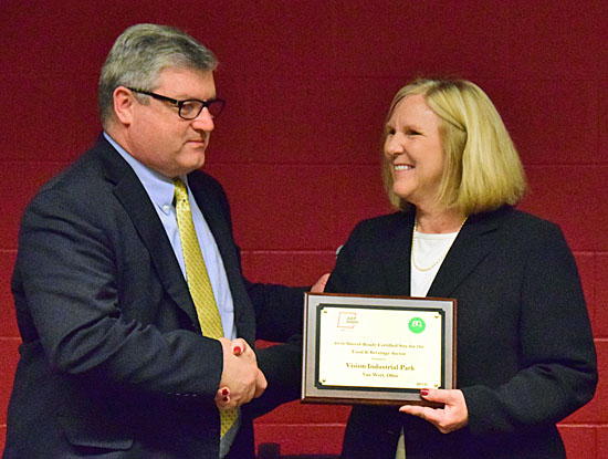 Tim Wells of AEP Ohio (left) presents local development director Stacy Adam a plaque recognizing the certification of Vision Park as certified for food and beverage manufacturing. Dave Mosier/Van Wert independent 