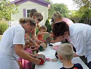 Mothers help their kids build birdhouses during a 2016 program at the Children’s Garden in Smiley Park. (photo submitted)