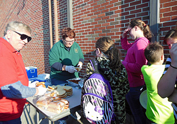 Shown are Elks Lodge 1197 Exalted Ruler Charles White (left) and Lodge Organist Linda Stanley feeding some of the kids. Also lodge members grilling the food for the hungry kids. (Elks photo)