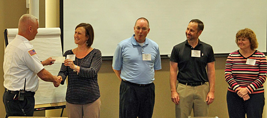 Shonda Vorst of the Van Wert Insurance Professionals chapter, presents a check for $400 to Van Wert Fire Chief Jon Jones, as other chapter members look on. (photo submitted)