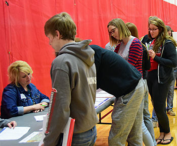 Van Wert High School government students line up to obtain financial information from one of the Real Money, Real World program stations in the VWHS gym on Tuesday. Dave Mosier/Van Wert independent